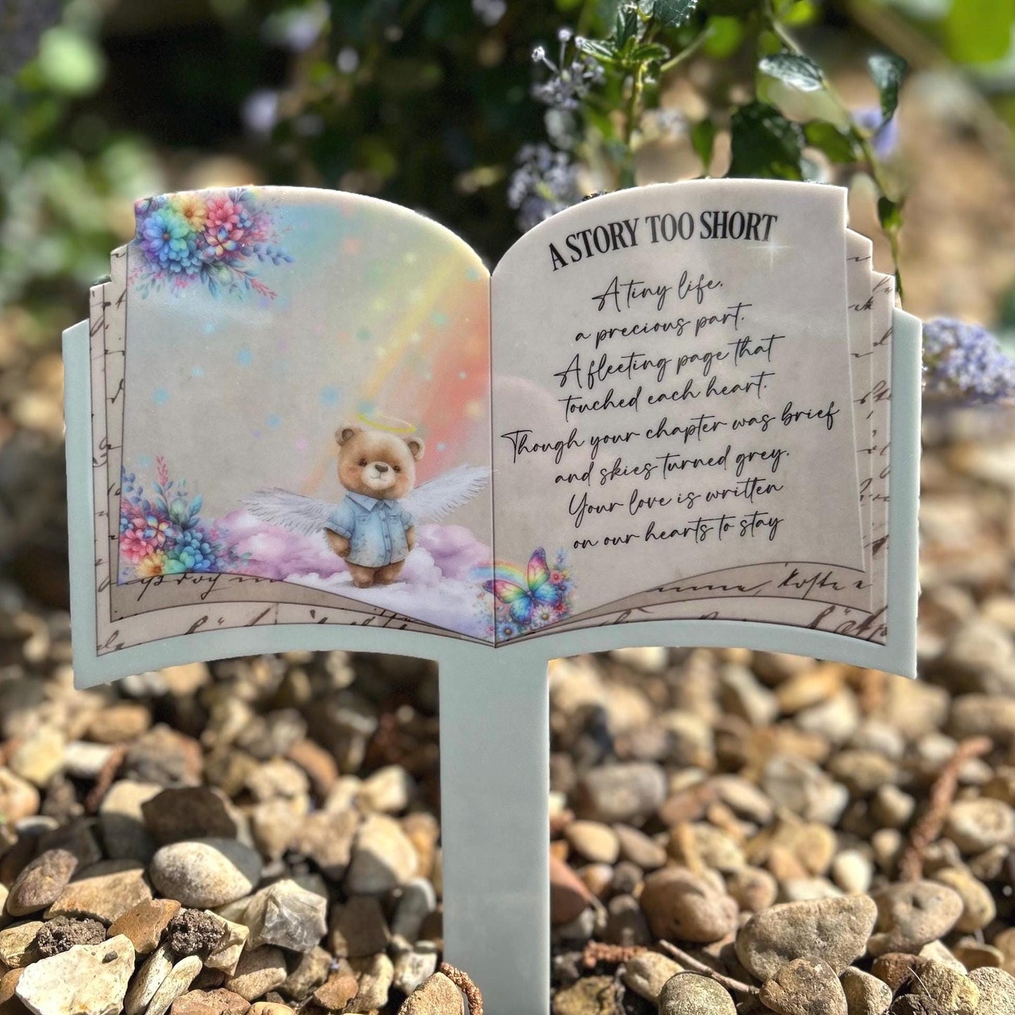 Blue teddy open book grave marker placed at a graveside