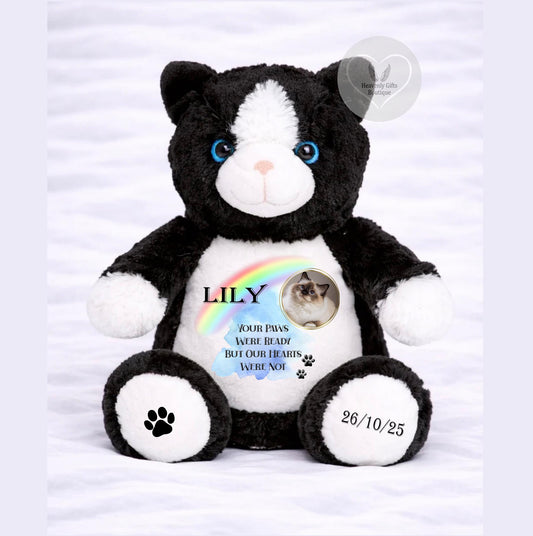 A black and white stuffed teddy bear with a personalized message and a photo of a cat on its belly.