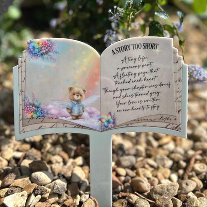 Blue teddy open book grave marker placed at a graveside