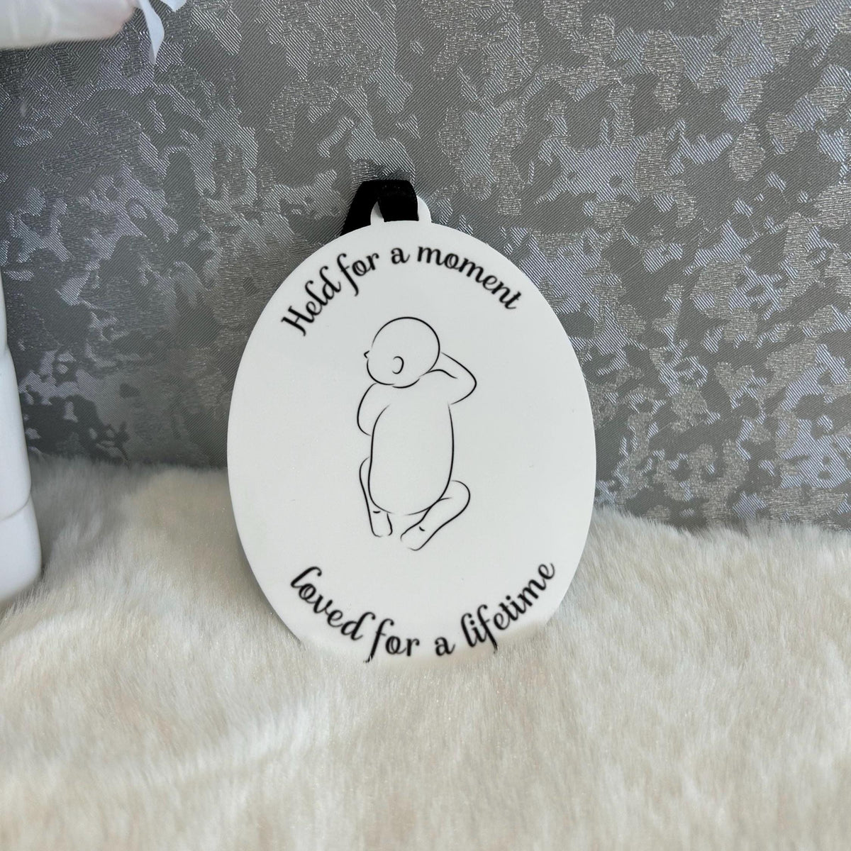 Oval baby loss remembrance decoration with minimalist baby outline and black ribbon
