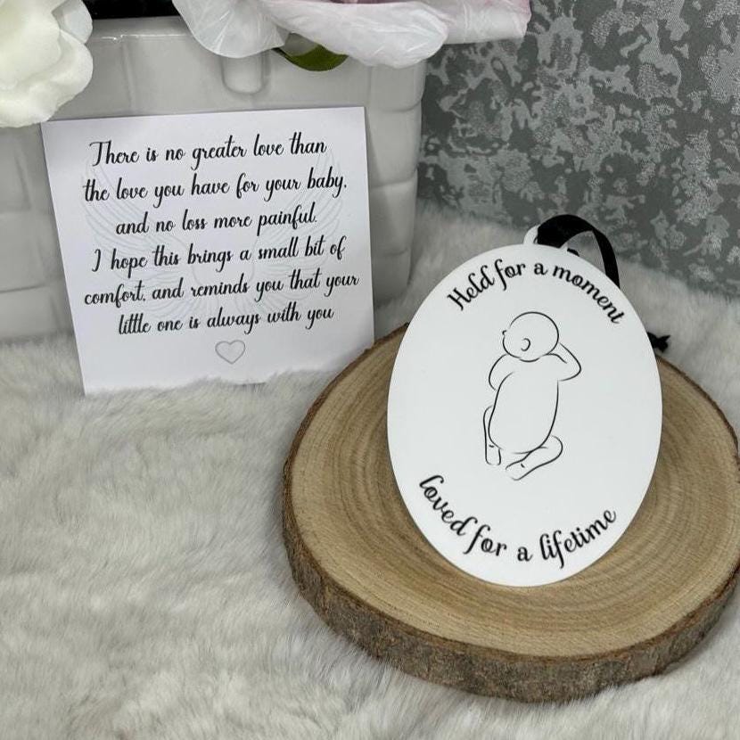 Close view of baby loss memorial decoration beside a comforting message card