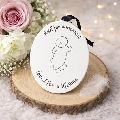 Oval baby loss memorial hanging decoration with infant outline and Held for a Moment quote