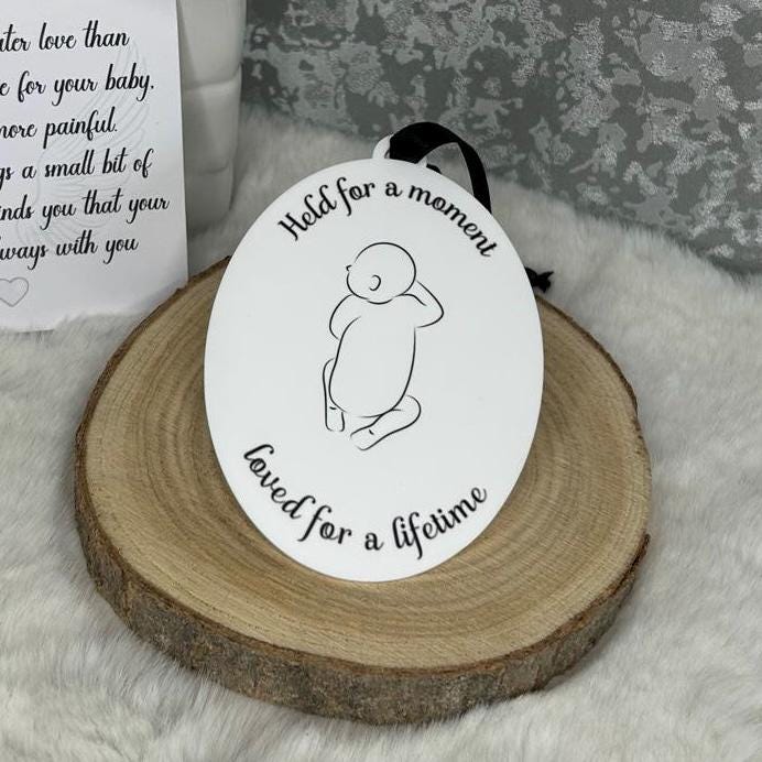 Held for a Moment baby loss memorial decoration displayed on a wooden slice