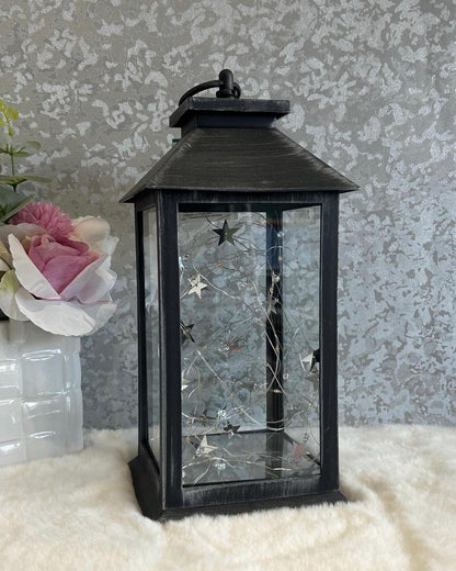 Side view of black and grey large memorial lantern with star-shaped LED lights