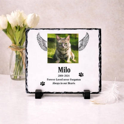 Personalised cat memorial photo slate displayed with white flowers and a feather