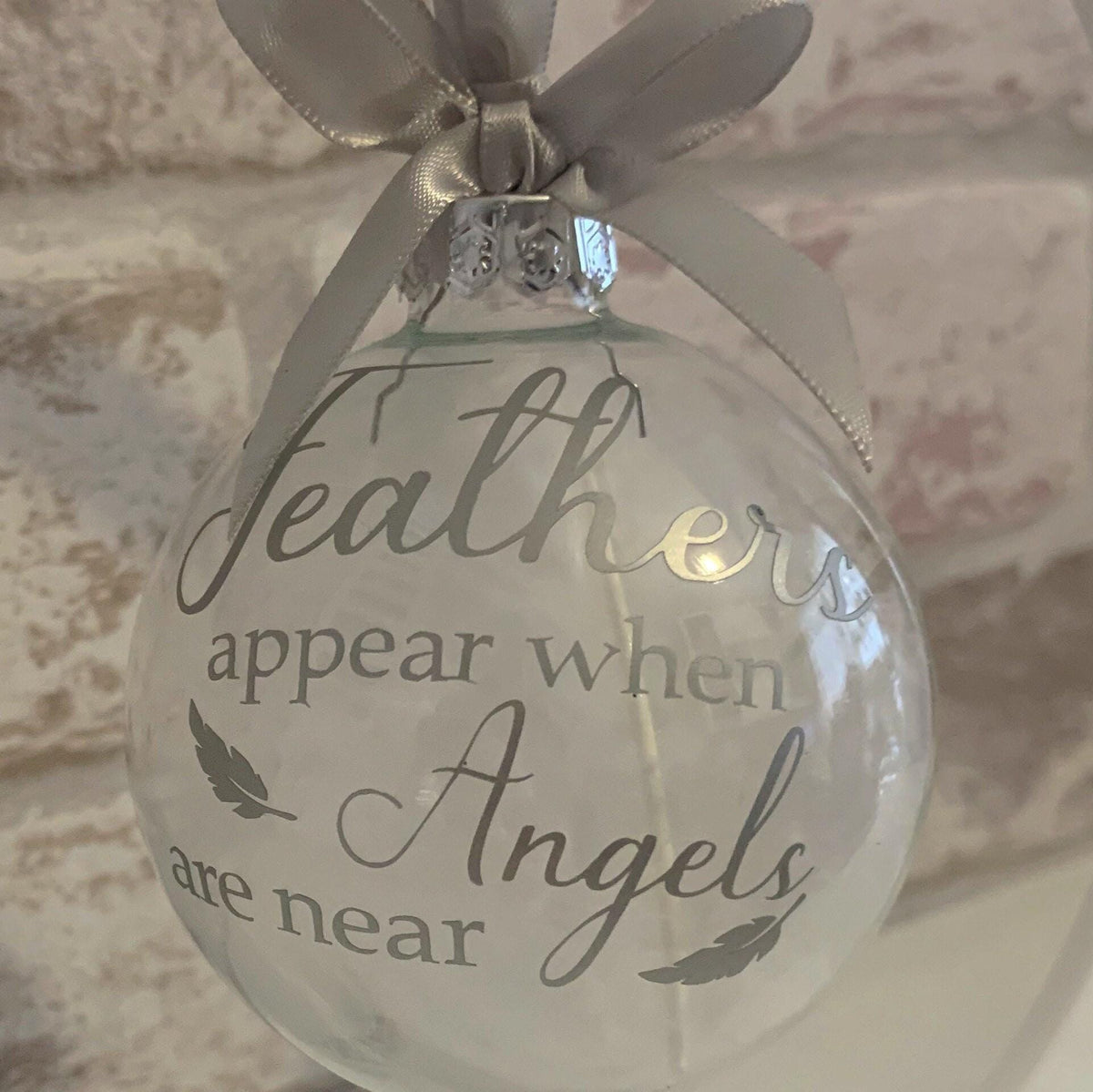Christmas remembrance bauble with white angel feathers