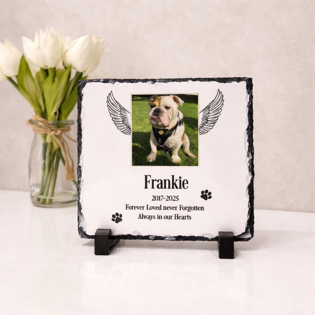 Personalised pet memorial photo slate displayed on a stand beside white flowers