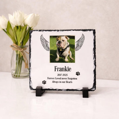 Personalised pet memorial photo slate displayed on a stand beside white flowers