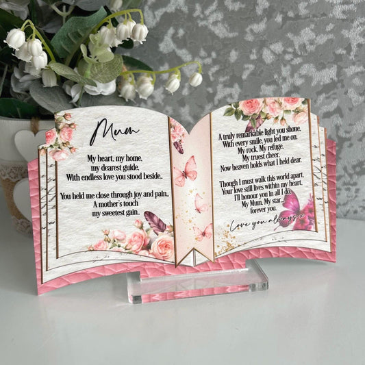 Open book memorial plaque with pink floral and butterfly design