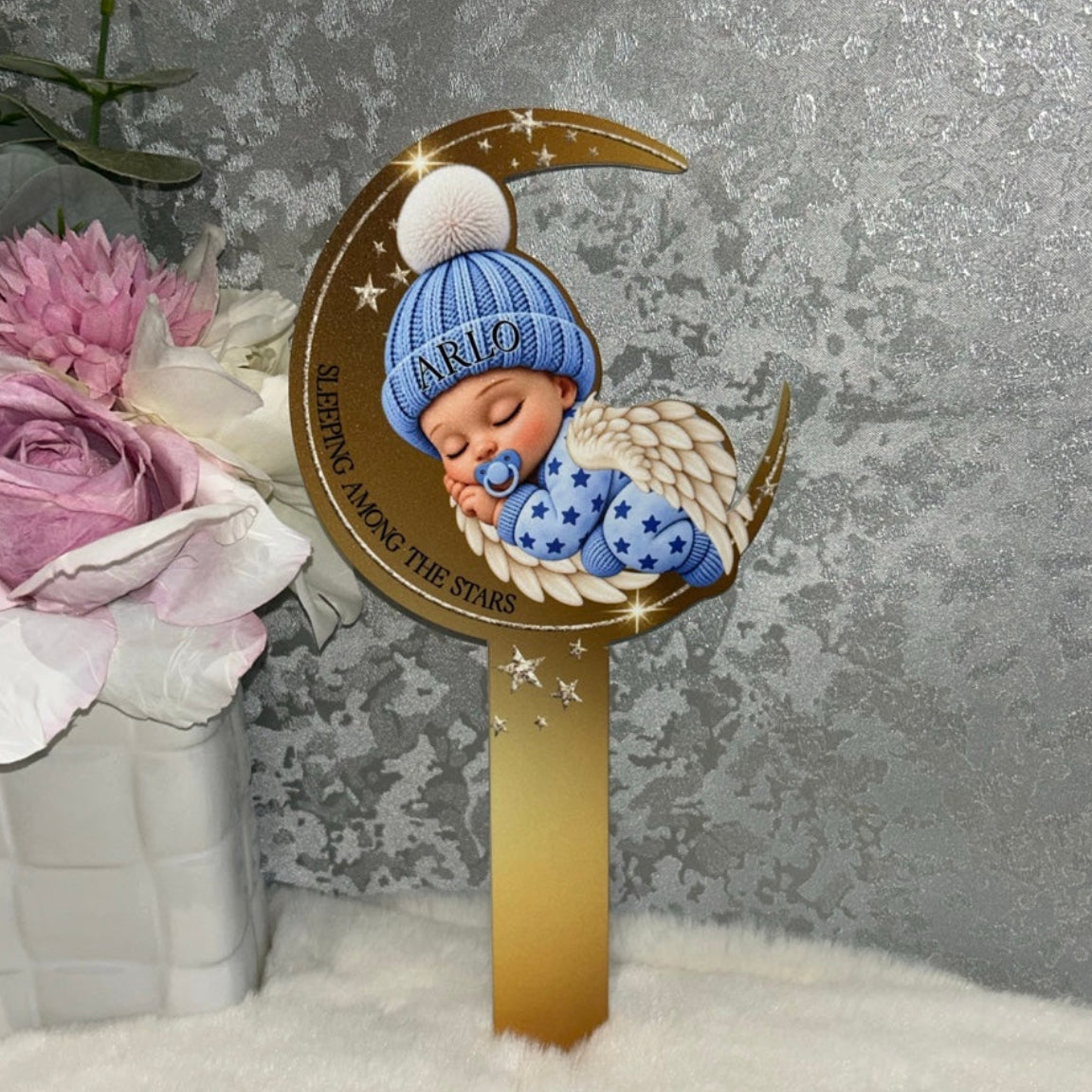 Personalised blue Sleeping Angel Baby grave marker with name Arlo on baby's hat, gold crescent moon, angel wings and Sleeping Among the Stars wording.