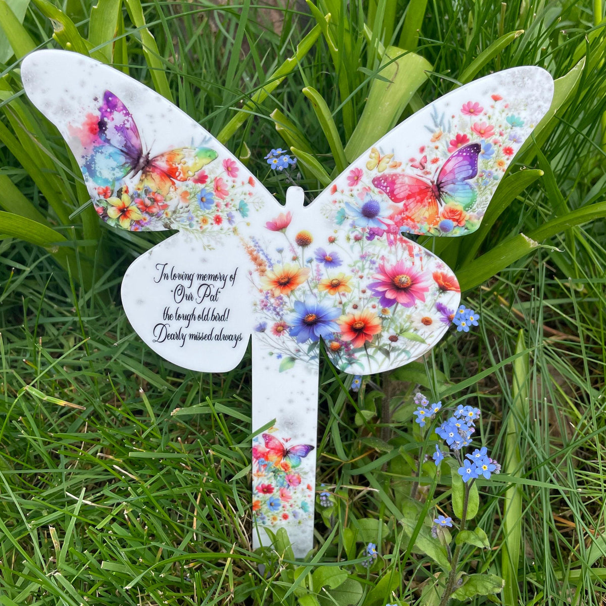 Rainbow butterfly graveside memorial with colourful wildflowers