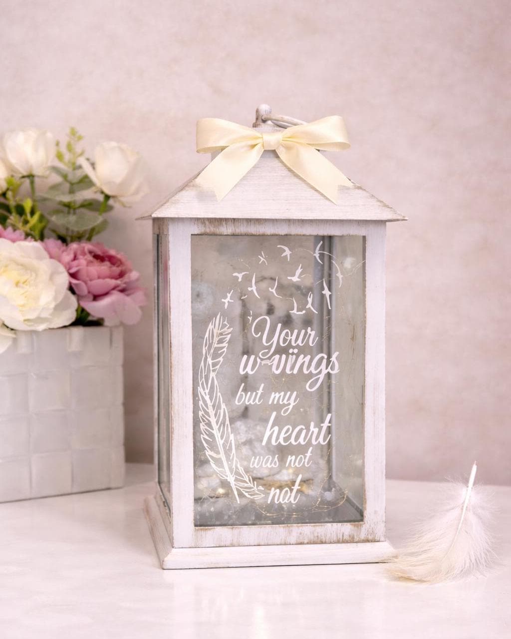 Angled view of white large personalised memorial lantern with cream bow and LED lights